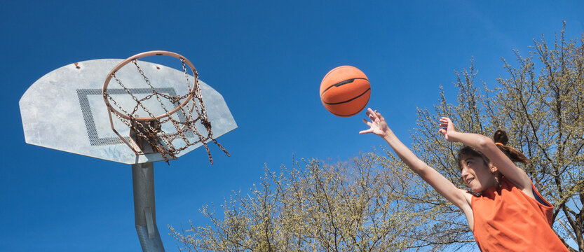 Boy taking a basketball shot.