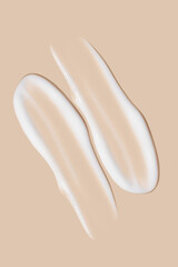 a set of strokes of white cream on a beige background.