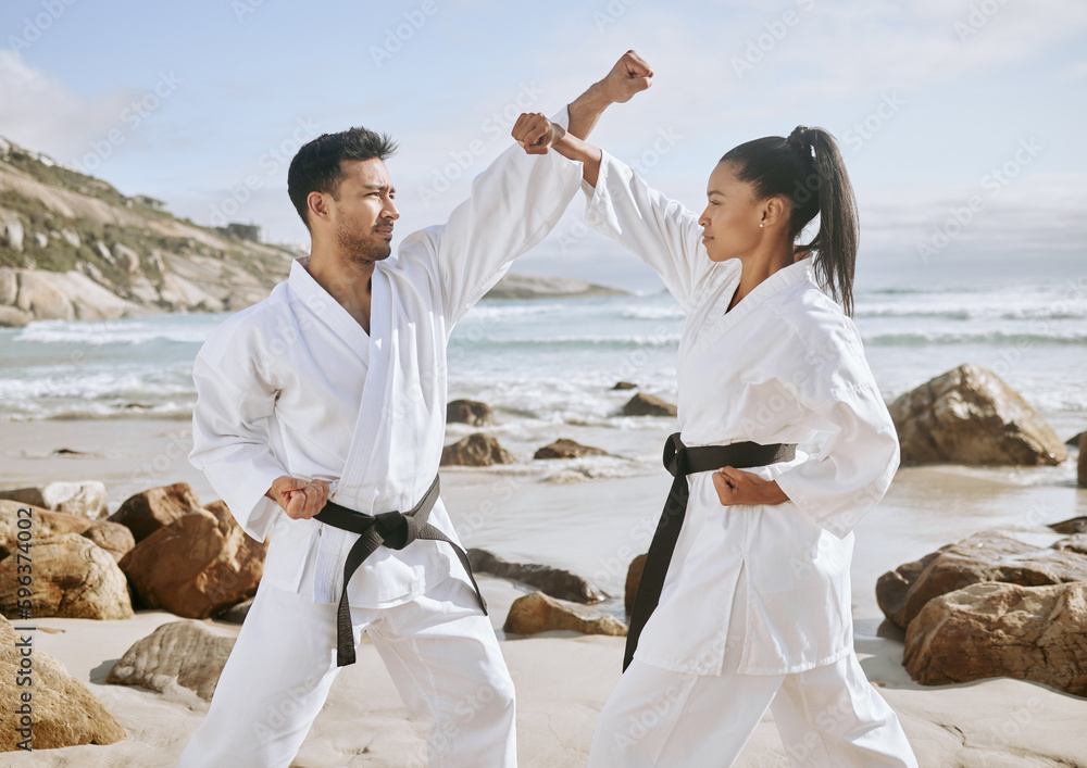 Poster Packing power into their punches. Shot of two young martial artists practicing karate on the beach.