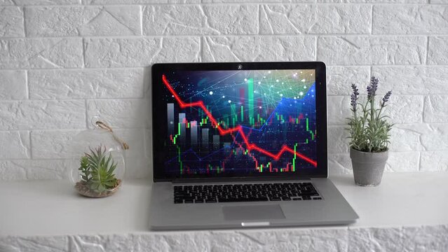 Global economic recession, stock market crash and inflation concept with digital falling down red candlestick and diagram on modern laptop keyboard background