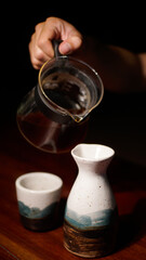 coffee poured into japanese sake ceramic bottle, manual brewed menu on coffee shop
