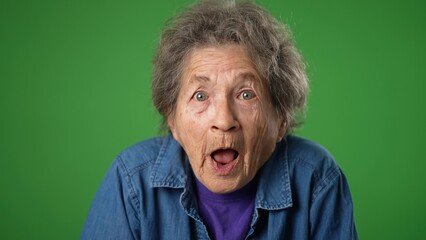 Closeup funny toothless portrait of elderly senior old woman with wrinkled skin and grey hair has great success winner isolated green screen background in studio. People emotions concept