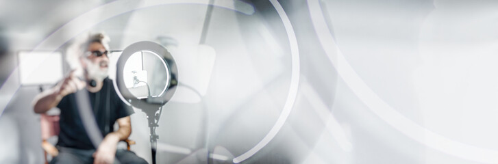 Radio host, charming influencer, records a live show with equipment. Panoramic banner background...