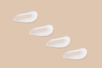 a set of strokes of white cream on a beige background.
