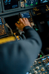 Close-up of a pilot's hand pressing the throttle in the cockpit of a jet plane reducing engine power