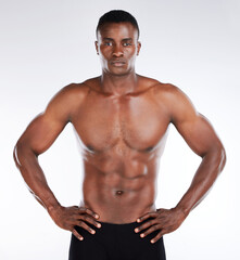 You could bounce a quarter off those abs. Shot of a handsome young man standing alone in the studio and posing shirtless.