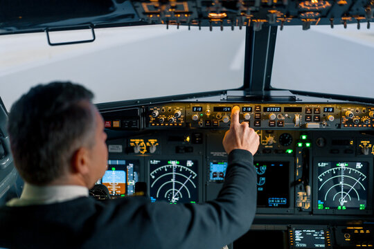 The pilot presses the power buttons on the control panel to control the aircraft in front of the cockpit windshield