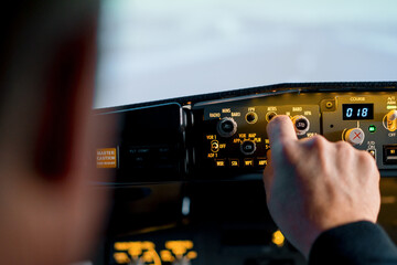 The pilot presses the power buttons on the control panel to control the aircraft in front of the...