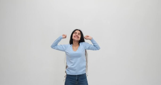 Ecstatic woman celebrating success by raising arms and clapping hands