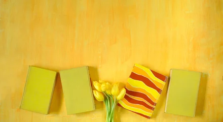 Fototapeten beautiful spring flowers, yellow tulips flowers with books on yellow background, concept, flat lay, negative space,free copy space © Kirsten Hinte