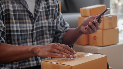 Entrepreneurs Small Business SME Independent men work at home Use smartphones and laptops for commercial checking, online marketing, packing boxes, SME sellers, concept, e-commerce tea