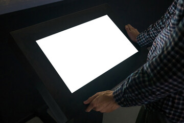 Mock up, copyspace, template, education, future and technology concept - man looking at white blank interactive touchscreen display kiosk in dark room of modern technology museum - close up view