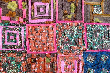 textile background - stitched back side of handcrafted motley patchwork cloth close up