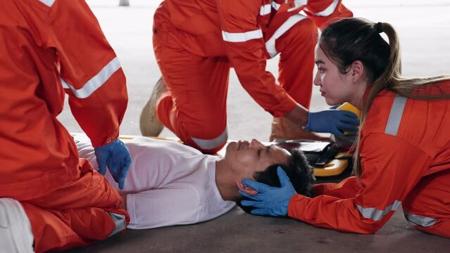 Group of Asian emergency medical technician (EMT) or paramedic team is holding manual stabilization of the head patients and wearing neck collar, Emergency medical services (EMS) nurses concept