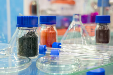 Medical glass bottles and vials in showcase at pharmaceutical exhibition, pharmacy laboratory - close up. Pharma industry, science, medicine, experiment and healthcare concept