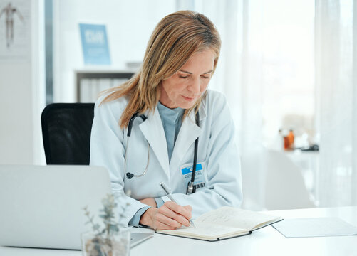 I better take note of these medicinal side effects. Shot of a mature doctor sitting alone in her clinic and writing notes.