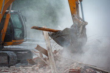 Demolition of building. Excavator breaks old house. Freeing up space for construction of new building
