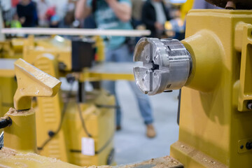 Fototapeta premium Close up view: wood turning lathe machine with shavings at workshop. Carpentry, industrial, woodwork and manufacturing concept