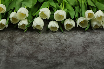 Beautiful bouquet of white tulip flowers with card on grey background, space for text