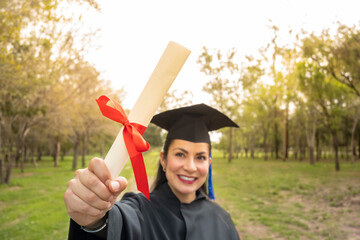 selective focus of latin woman holding her graduation degree