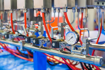 Part of industrial machine equipment with pressure gauge and flexible plastic hoses at exhibition, trade show. Manufacturing, production, technology concept