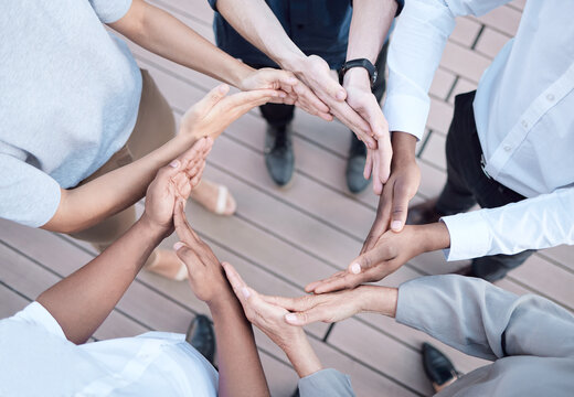 When we all help one another, everybody wins. Shot of a group of unrecognizable businesspeople forming a circle with their hands.