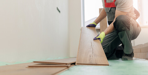 Banner renovation apartment, Professional builder man laying laminate flooring at home
