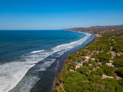 An aerial view of houses and coastline along the Majahual beach in La Libertad, El Salvador