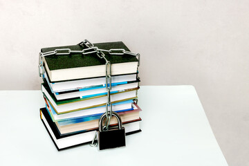 stack of books wrapped in a chain and padlocked