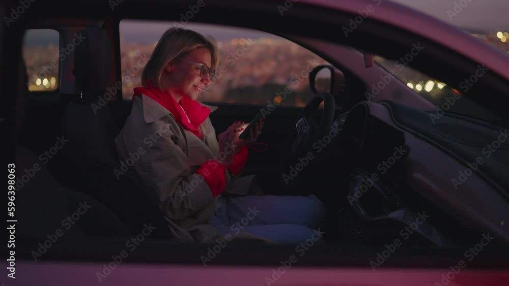 Poster content creator sitting in car, working on latest blogging post using trusty mobile phone applicatio