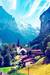 Fototapeta na wymiar The Incredible picturesque landscape in Lauterbrunnen with canyon, church and famous Staubbach waterfall in the Swiss Alps, Switzerland. Amazing places.