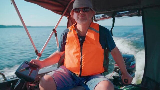 Braslav, Belarus, 05.08.22: A man in a motorboat operates an echo sounder