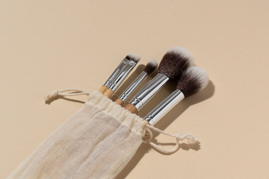 Close-up of natural brushes for applying powder or tone on makeup on a beige isolated background. Concept of beauty and skin care products