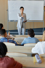 Vertical image of teacher talking to students and asking questions to them at lecture at university