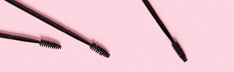 Flat lay top view mascara brushes on pastel pink background