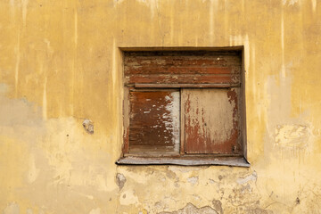 Boarded up window in an old dilapidated stone wall