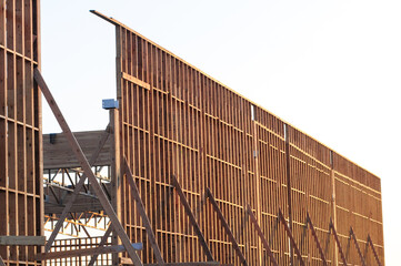 Partial exterior view of a large commercial building under construction showing its wood framing stage