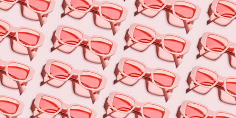 Minimal pattern from pink eyeglasses on rose background, visual trends summer concept. Top view...