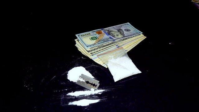 Dolar and a bag of white powder, on a black background