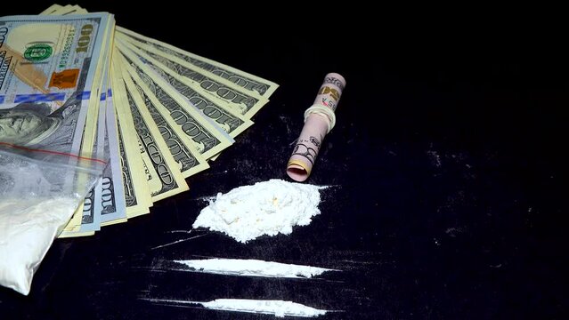 Dolar and a bag of white powder, on a black background