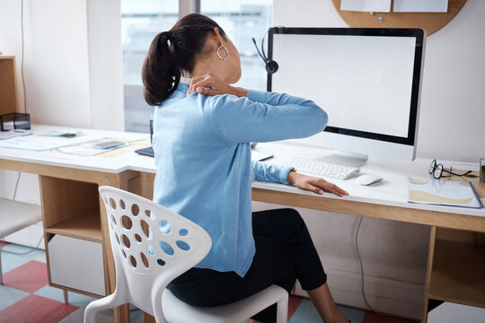 Long hours will take their toll. Shot of a businesswoman experiencing back pain while working at her desk in a modern office.