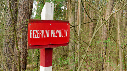 Nature Reserve sign in Poland, signpost of nature conservation area in forest. Rezerwat Przyrody.