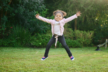 Shes just a burst of energy. Portrait of an adorable little girl jumping outdoors.