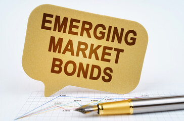 On the business diagram is a pen and a sign with the inscription - emerging market bonds
