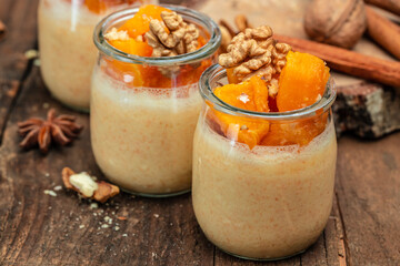 Creamy dessert with pumpkin mousse on a wooden background. place for text.