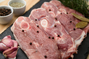 Flat lay of some lamb chops, with bay leaf, peppercorns, garlic, rosemary