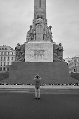 A man standing in front of a memorial in Riga, Latvia