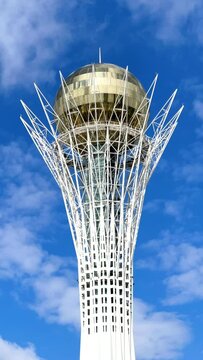 Astana, Kazakhstan, April 2023. Baiterek against a blue sky with clouds. Time lapse vertical video.