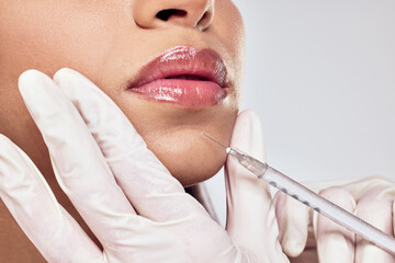 One syringe for all your dreams. Shot of a woman having her chin injected with botox against a...
