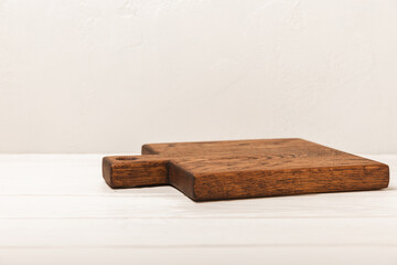 Cutting board on a white wooden kitchen table. Menu food card or recipes background concept.MOCKUP. Design. Place for text, copy space. The concept of food and cooking.